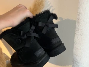 Uggs med rosett  - Svarta uggs med rosett i storlek 40. Använda men i bra skick. Säljer då de är för stora. Nypris 2200 