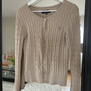 Kabelstickad kofta  - Kabelstickad kofta från GANT. Strl small, använd men i bra skick.  Nypris 1399 :-   