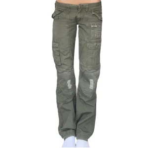 Cargobyxo 2000s yk2 - Skit snygga vintage 2000s cargobyxor, dem är lågmidjade med utsvänga ben. Snygga detaljer och flera fickor.  Mått - midja 76cm innerbensmått 81cm ( bilden är 170cm) 