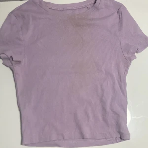 T-shirt - Säljer denna lila magtröjan. Använd ganska många gånger men har inga fläckar.
