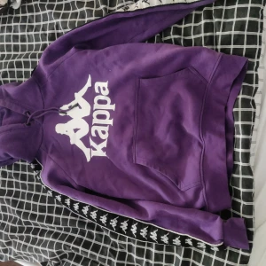 Kappa huddie - En mörk lila kappa huddie. I storlek M.