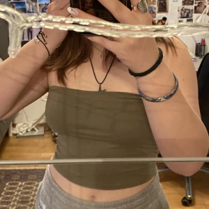 Olivgrön bandeau top - Simpel bandeau top. Hade ursprungligen band, dessa har klippts av men det syns inte. 