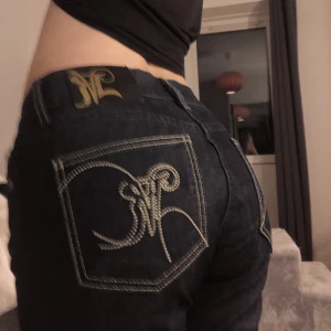 Lågmidjade jeans - Säljer dessa lågmidjade jeans i storlek 28/34. Dem är mörkblå med gulddetaljer! Inga defekter.