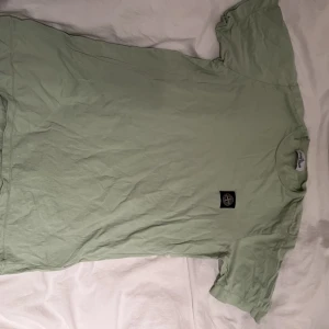 Stone Island Junior T-shirt - En Stone Island Junior T shirt köpt på Nk för ungefär 1000kr Färg: ljus grön Storlek: 14/170 (S)