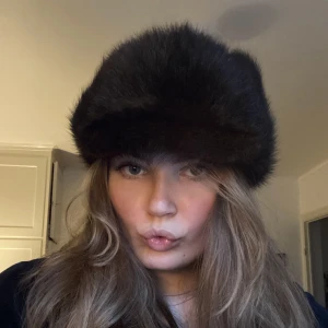 Pälsmössa - Superfin pälsmössa i äkta päls! Gissar på mink eller liknande, mjuk och fin päls. Kommer tyvärr inte till användning då den är lite för liten för mig. Den har som en liten skärm fram och öronlappar man knyter upp. 