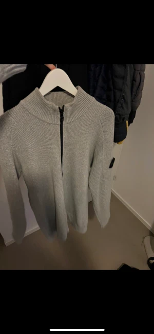 Stone island stickad zip up tröja - Grå Stone island tröja.  Endast använd fåtal gånger därav mycket fint skick, nypris 4100 kr. Kan visa kvitto och allt, köpt på Farfetch. Säljer för 1250  kr eller billigare vid snabb affär! 