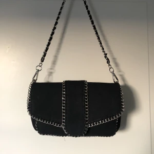 Noella väska  - Säljer denna svarta noella väska med silverditaljer då den inte kommer till användning.💕 den har två fack var av i de stora facket finns det en liten ficka med dragkedja. Inga skador! Nypris: 649kr säljer den för 400. Fler intresserade blir det budgivning