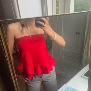 Röd volangtopp från Zara - Fin röd topp med snygga detaljer!!! Köparen står för frakten. Säljer pågrund av att den ej kommer till användning, nyskick❤️ Kan även användas som kjol. Pris kan diskuteras!
