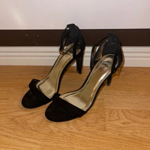 Svarta klackar - Svarta klackar med band runt fotleden