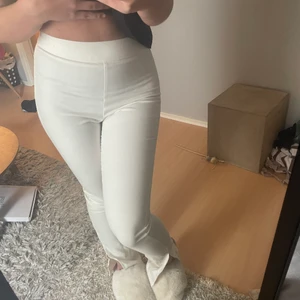Byxor - Ett par vita/beiga byxor med en slits från Nelly x biancas kollektion! Använda 1 gång. Storlek 38 men skulle nog passa en 36 med! Sjukt snygga och bekväma!