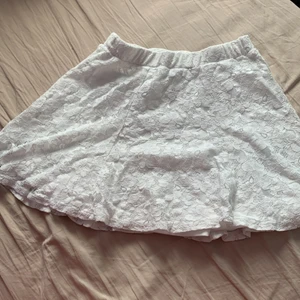 Kjol - Kjol som aldrig använt som har ett vitt blommigt mönster. Väldigt söt och har ett extra tygglager under mönstret så att inget syns!☺️ Har en tröja som passar som säljs separat!