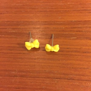  - Gula örhängen i form av rosetter. Ca 8mm stora.