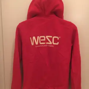 Oanvänd WESC-tröja i strl M. Röd med text på ryggen i gul. 