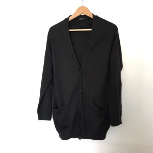  - Ärvd och använd så en aning noppig, se sista bilden. Man kan vika upp ärmarna och knäppa fast, syns på sista bilden. Längd ca 75 cm. 100% akryl