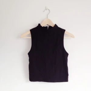  - Svart polotopp med dragkedja i ryggen. Passar till allt:-) 