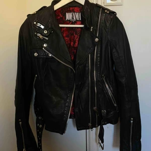  - Jofama by Kenza jacka, äkta skinn. Köptes för 4000 kr, använd ett fåtal gånger - i nyskick. Superfin jacka med vacker passform. Röd insida med spetsdetaljer. Silverdetaljer, dragkedjor och ett bälte.