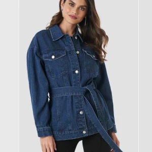  - Belted Denim jeansjacka från NAKD i fint skick, endast använd fåtal gånger. Storlek XS/34.   Frakt betalas av köparen!     