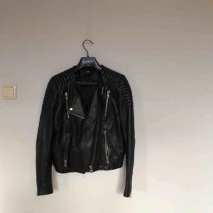  - Bikerjacka i äkta läder från H&M (the new icons-kollektionen), storlek 36. Sparsamt använd, hängt i garderoben i några år. Fint skick, normal i storleken.   Köparen betalar frakt, alt avhämtning i Gävle eller Uppsala! 