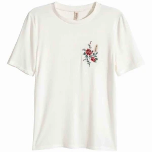  - Vit tunn T-shirt från h&m med blomsterbroderi på bröstet. Fint skick, inga hål eller missfärgningar. Kan skicka fler bilder (dåligt ljus hemma nu). Strl S  Finns i stockholm, annars tillkommer frakt 