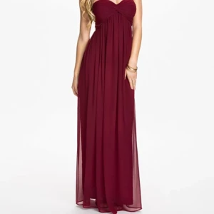  - Långklänning från Nelly.com, aldrig använd. Nypris ca 600kr, färg burgundy (vinröd). Väldigt fin passform upptill, säljes pga för lång för mig. Storlek S.