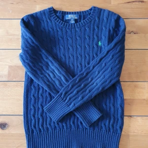 Ralph Lauren Kabelstickad  - Säljer kabelstickad ralph lauren tröja i storlek M/10-12 i barnstorlek, skriv till mig för mått! Bra skick utom lite användning som syns på armbågarna. Säljs pga att den är för liten!