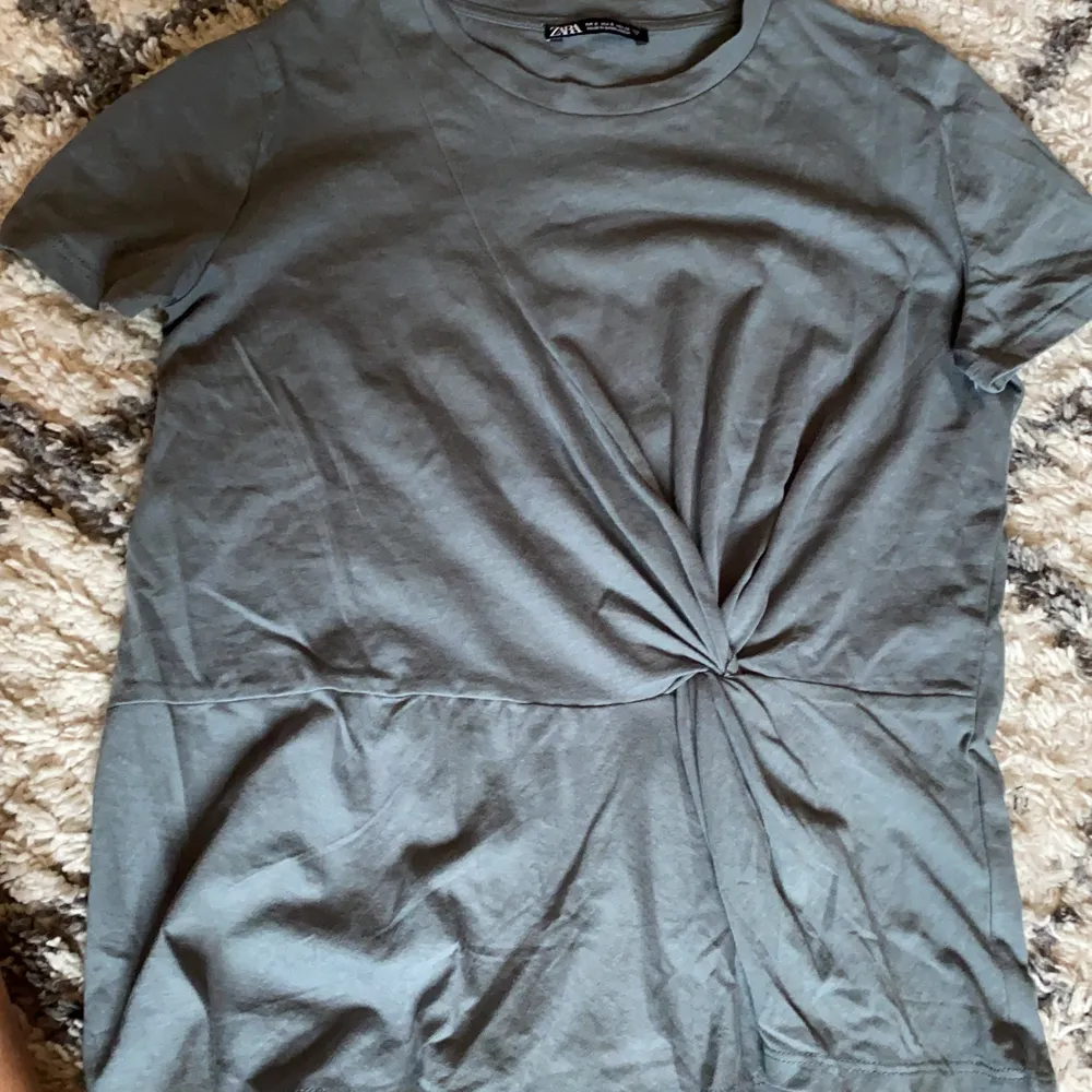En oanvänd mörkgrön T-shirt från zara med en liten knytning (inkl frakt). Blusar.