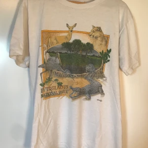 Vintage Tee med tryck - En skön vintage T-shirt med tryck. Kan användas som oversize eller fitted beroende på användarens strl. Vit på ryggen. Inga större fel men använd flitigt. Möts i Stockholm eller så står köparen för frakt. ✨✨✨