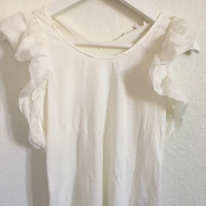Topp från Chloé - Söt topp med volangärmar från märket Chloé i storlek xs. Helt oanvänd med prislapp kvar. Nypris 460kr (45euro). Säljs för 300kr. Kan mötas upp i Skövde eller Hjo. Skickas mot fraktkostnad.