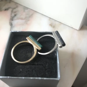 Ringar - Två st ringar, en guld och grön, en silver och svart, båda med ”marmor”. De är stora så passar inte folk med mindre fingrar. 1 för 30, 2 för 45.
