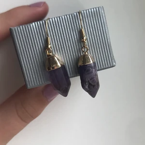 Lila örhängen - Ett par häng örhängen med lila stenar. Den ena är lite skadad (visas på 3e bilden) och därav priset. Nypris: 200