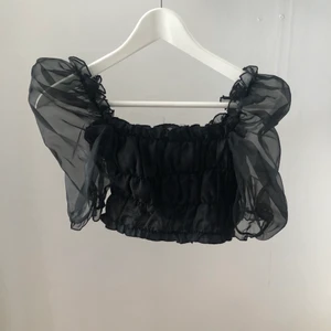 Topp med puffärm - Topp från Nelly använd endast 1 gång. Stl 38 men känns mer som en 34, men är väldigt stretchig. Perfekt festtopp med genomskinliga puffärmar och croppad passform⚡️⚡️ 130 kr med frakt, nypris 299:-