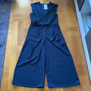 HELT NY! Byxdress strl. 44 - Helt ny! Mörkblå byxdress den Vila strl. 44. Pris exkl. frakt, köparen står för frakten.
