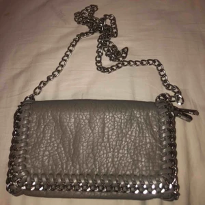  - Liten grå väska köpt på scorett. Långt kedja axelband. Säljer pågrund av att den inte kommer till användning längre💗💗