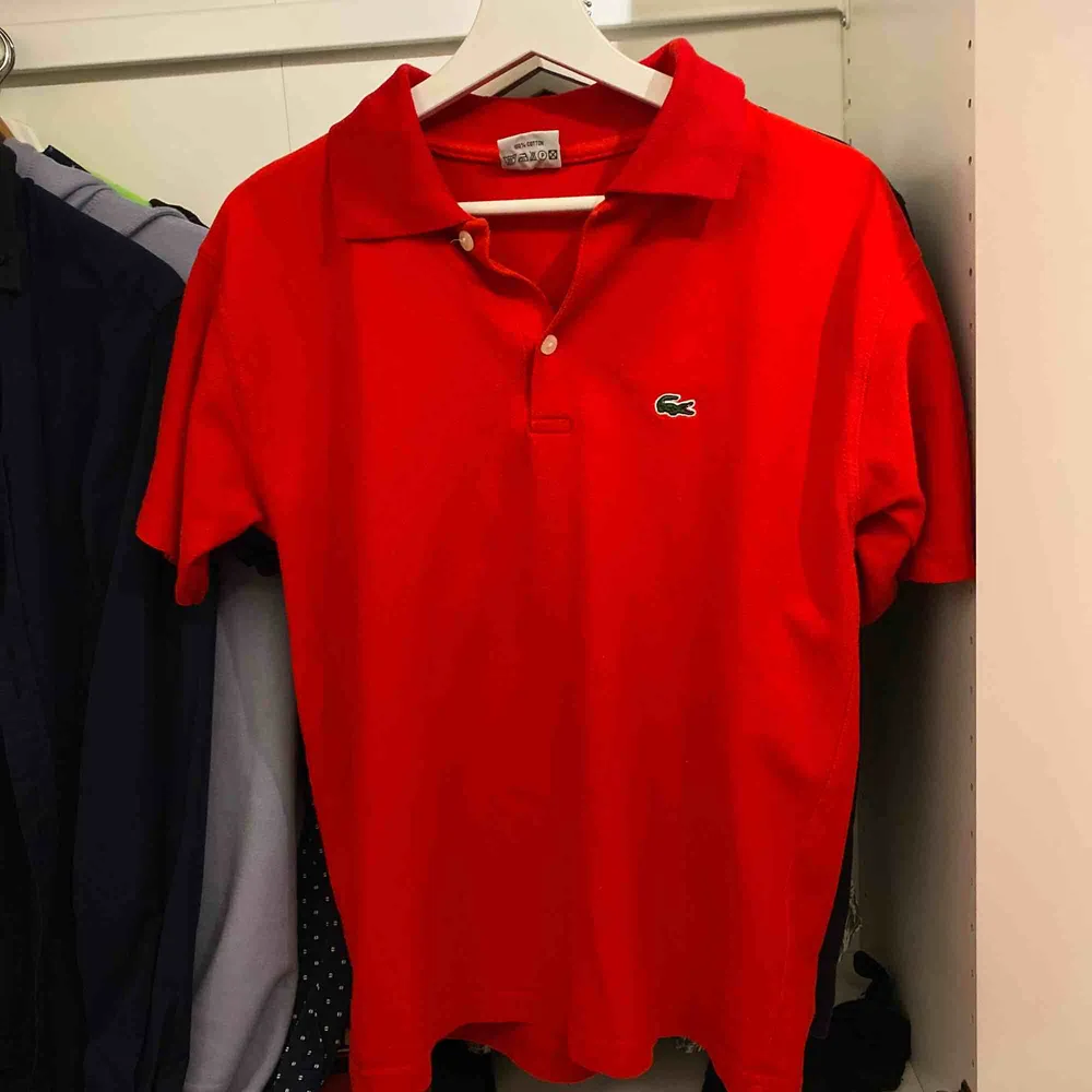 Röd Lacoste i bra skick med grön logga Stl. M . T-shirts.