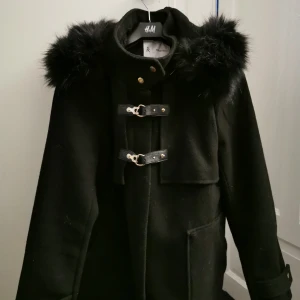  - En svart kappa som går ner till rumpan. Stor huva.. Höst jacka 