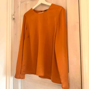  - Orange blus i sidenmaterial med slits i armen! Superfin i material och färg   Du som kund står för frakten!