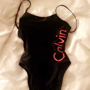  - Helt oanvänd Calvin klein ÄKTA baddräkt från Åhlens stockholm. Lågni ryggen där den röda pluppen sitter. Originalpris 599kr Köparen står för frakt. :-) 