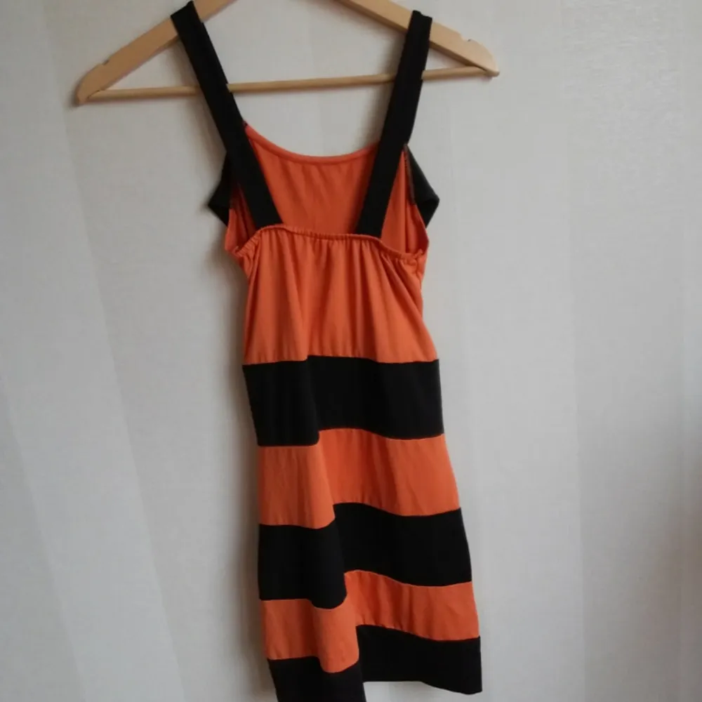 Klänning i orange svart i storlek s/m. Övrigt.