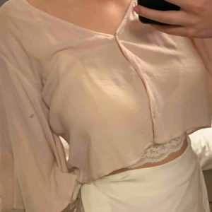  - En supersnygg blus/tröja med knappar som man kan ha både i ryggen och där fram. Man kan både knäppa upp den Elr knäppa den hela vägen upp. 1:a bilden är den helt knäppt och på den 2:e bilden är en knapp uppe.