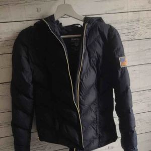  - En mörkblå dunjacka ifrån Intersport som värmer bra till vintern! Har använt kontinuerligt i några år men inte på sistone men är fortfarande i bra form! Köparen står för frakt, 25kr😊