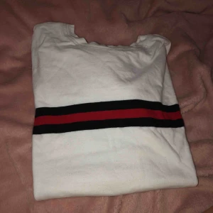  - Vit T-shirt med ett sammet sträck över! 2 svarta ränder och en röd, storlek s men passar xs också om man vill ha lite oversized 