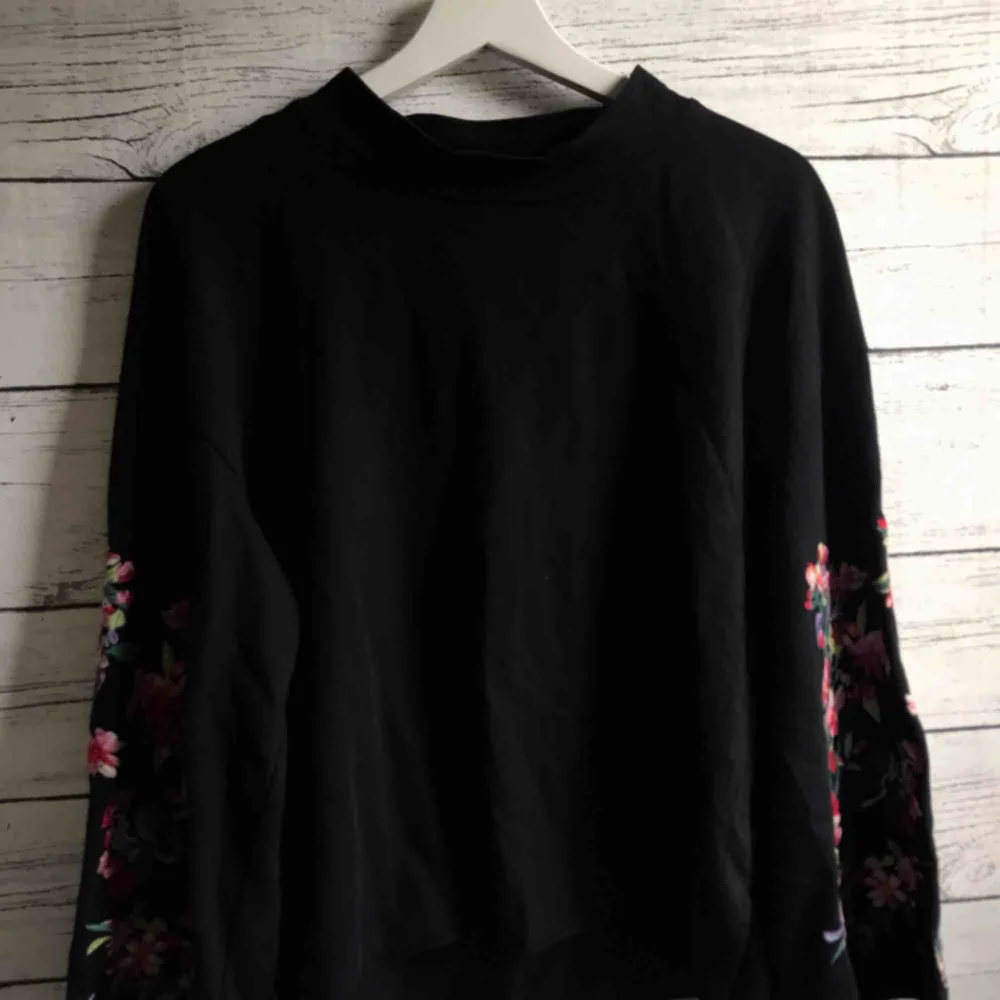 En långärmad svart tröja med vida ärmar som är dekorerade med broderande blommor! En tröja som både värmer och ser bra ut, har använts kontinuerligt  men är fortfarande i bra form. Frakt 25kr😊. Tröjor & Koftor.