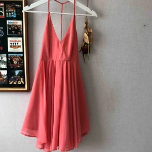  - Persika färgad klänning från Nelly. Öppen rygg med ett kors. Använd fåtal gånger. 