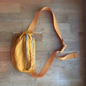  - Rymlig bumbag med justerbart band från Weekday. 