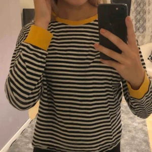  - En svartrandig tröja med gula detaljer! Knappt använd och i väldigt bra skick!