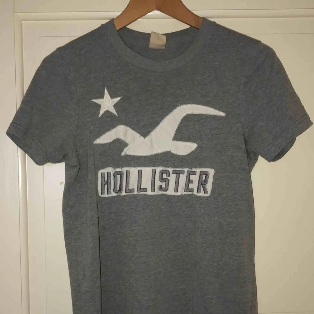 Grå Hollister T-shirt, storlek S (herr) M för dam och nästan aldrig använd. T-shirts.
