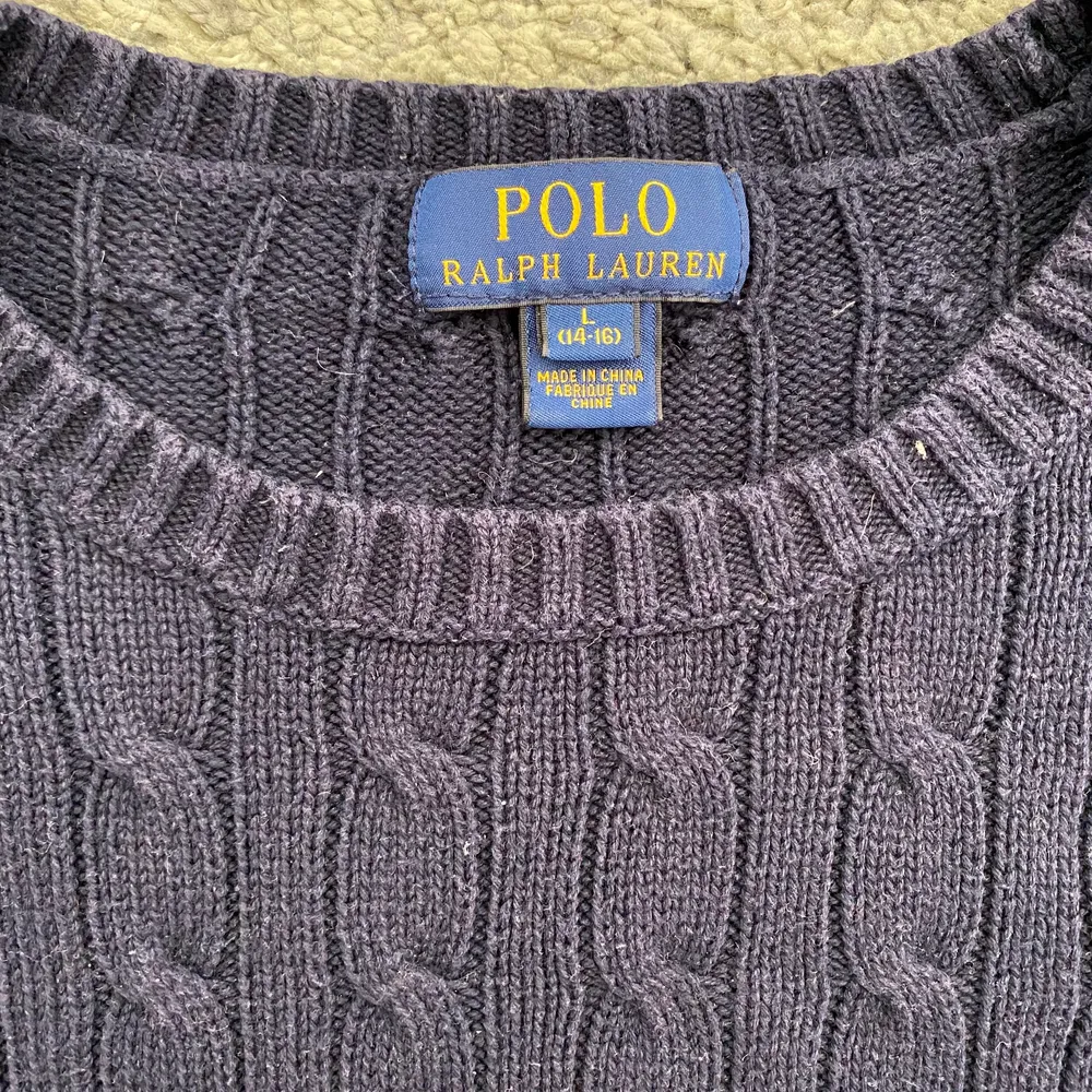 Marinblå kabelstickad tröja från Ralph Lauren i bra skick. Storlek 14-16 ÅR. Tröjor & Koftor.