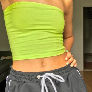 Neon tubtopp - Neongrön tubtopp från Asos. Använd 2 ggr, väldigt bra skick. Stretchig så passar nog fler storlekar än just 34. Hör av er vid fler frågor eller bilder <3