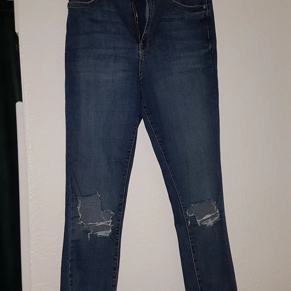 Blåa jeans i sliten stil. Jeansen är i storlek 42 och har en bra passform.. Jeans & Byxor.