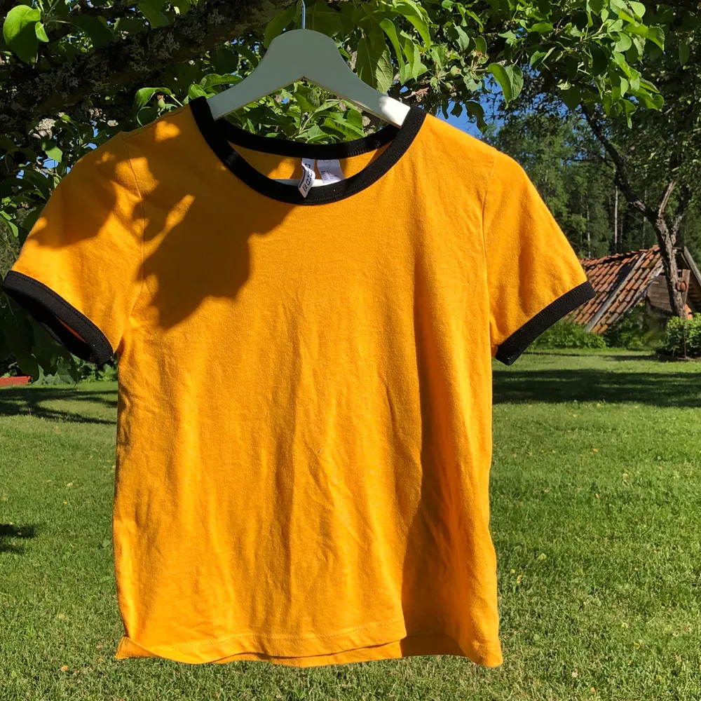 En gul t-shirt med svart runt nacke/armar. Skulle säga att storleken är mer utav en XS än en S, men det beror på hur man vill att den ska sitta😆 säljer då den inte längre passar☺️ pris kan självklart diskuteras! Köpare betalar frakt📦 kan samfrakta!🥰. T-shirts.